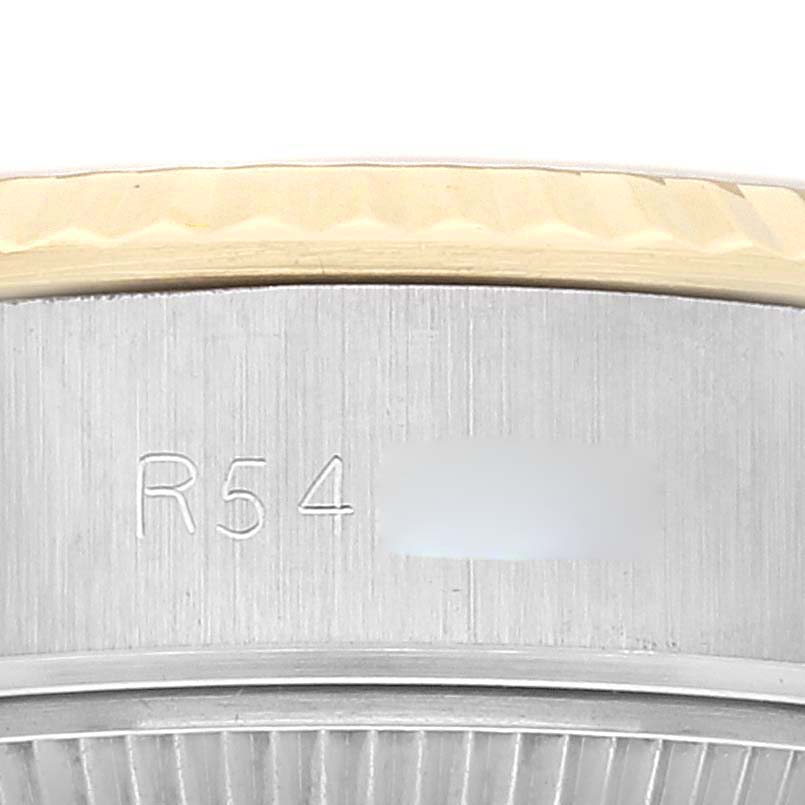 This close-up image of a Rolex Datejust 69173 Women's Steel and Gold (two tone) Champagne Dial 69173 Women's Steel and Gold (two tone) Champagne Dial watch shows part of the bezel and the serial number engraving on its case.