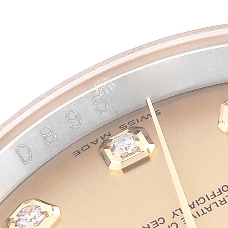 This close-up image of a Rolex Datejust 116233 Men's Steel and Gold (two tone) Champagne Dial 116233 Men's Steel and Gold (two tone) Champagne Dial shows part of the dial with diamond hour markers and part of the rehaut with engravings.