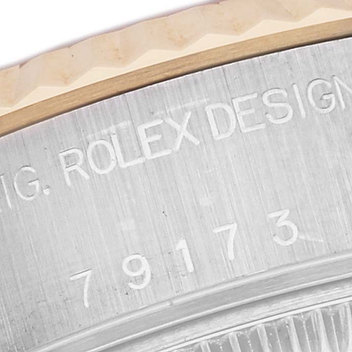 This image shows a partial side view of the bezel and engraved serial number of a Rolex Datejust 79173 Women's Steel and Gold (two tone) Silver Dial 79173 Women's Steel and Gold (two tone) Silver Dial watch.