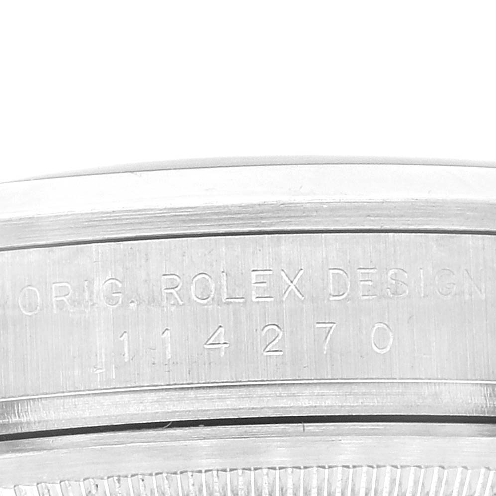 This image shows a close-up of the case side of a Rolex Explorer 114270 Men's Stainless Steel Black Dial 114270 Men's Stainless Steel Black Dial watch, focusing on the engraved text and model number.