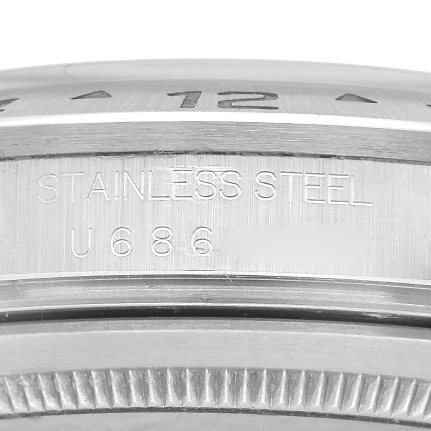 The close-up image shows the stainless steel case and bezel of a Rolex Explorer 16570 Men
s Stainless Steel White Dial 16570 Men
s Stainless Steel White Dial watch, focusing on the engravings.