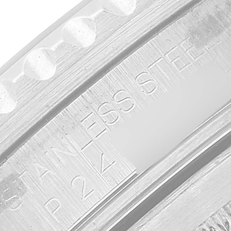 This is a close-up of the edge of a Rolex GMT-Master 16710 Men's Stainless Steel Black Dial 16710 Men's Stainless Steel Black Dial watch's bezel and part of the stainless steel case with engraved text.