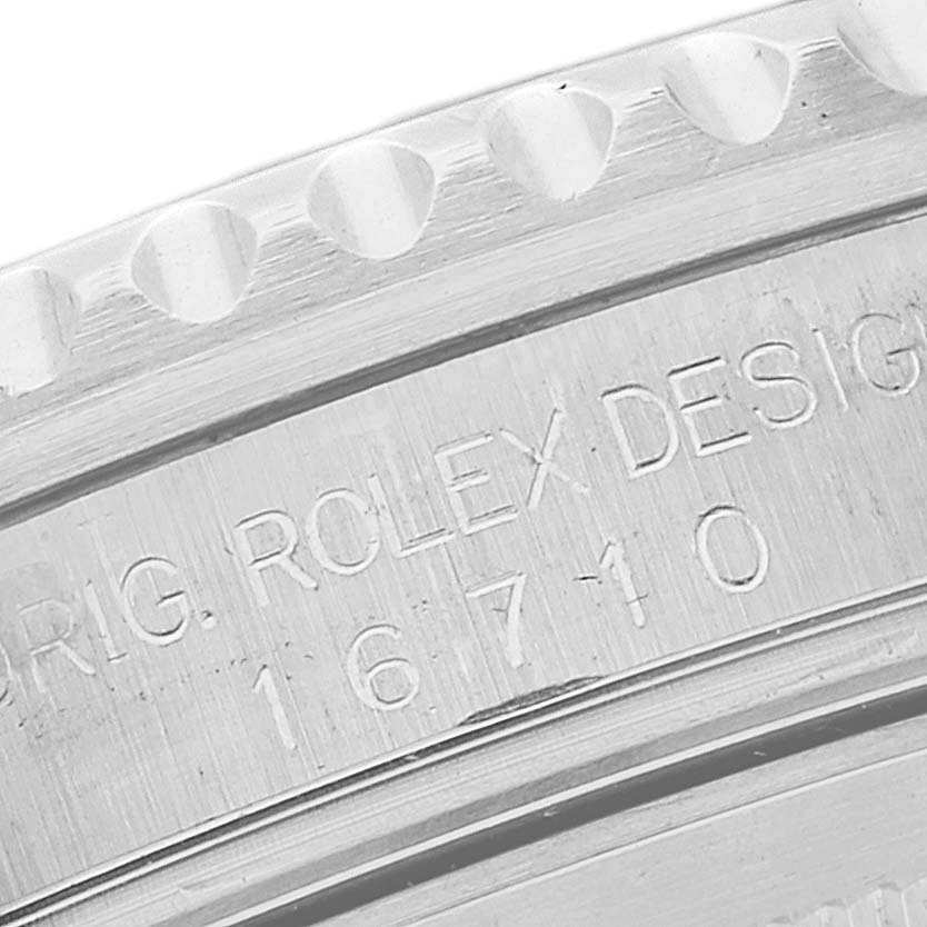 The image shows a close-up of the engraved case back and bezel of a Rolex GMT-Master 16710 Men's Stainless Steel Black Dial 16710 Men's Stainless Steel Black Dial model 16710.