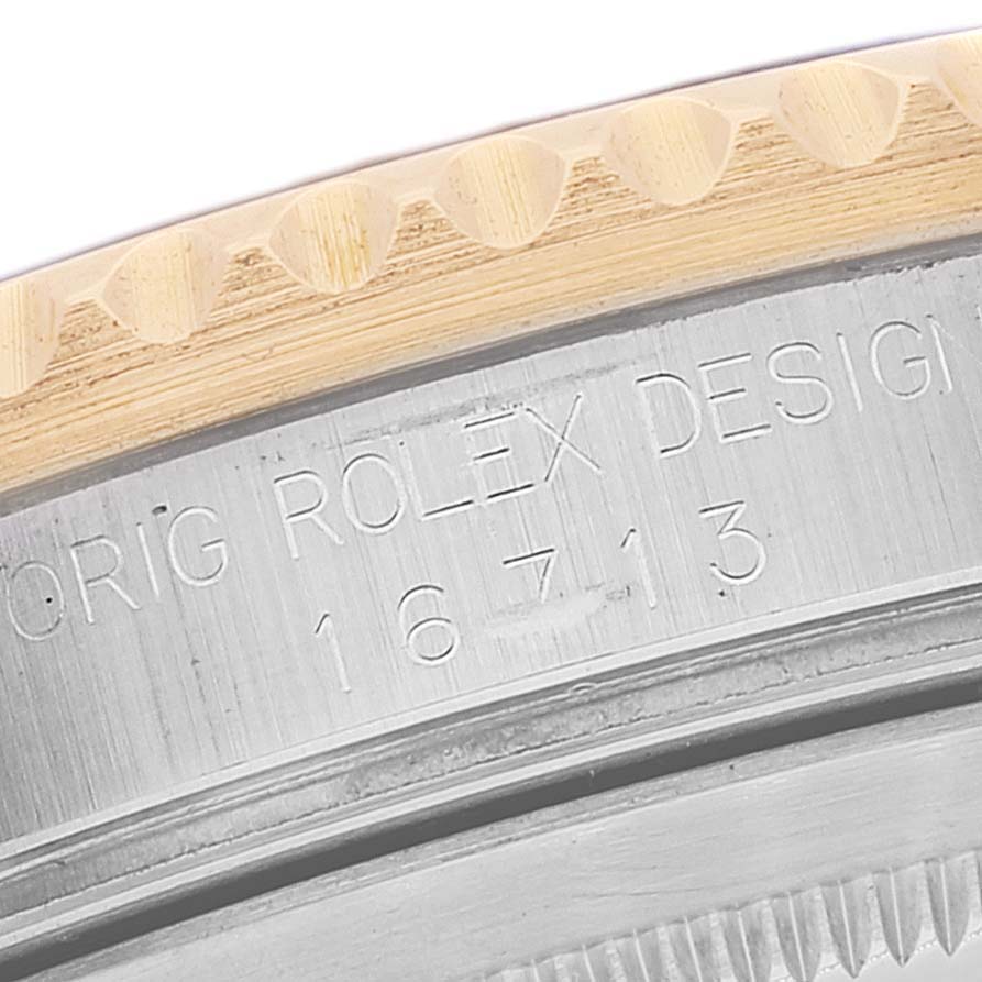 This image shows a close-up of the case side of a Rolex GMT-Master 16713 Men's Steel and Gold (two tone) Grey Dial 16713 Men's Steel and Gold (two tone) Grey Dial with the engraved model number 16713.