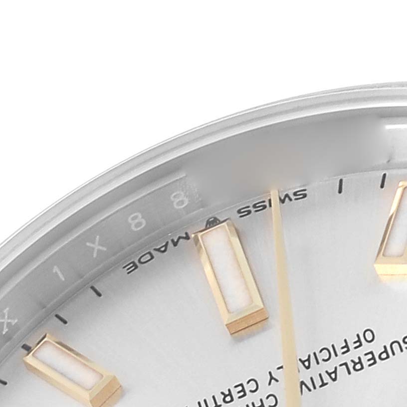 The image shows a close-up of the Rolex Mid-Size 277200 Women
s Stainless Steel Silver Dial 277200 Women
s Stainless Steel Silver Dial watch dial, highlighting a portion of the hour markers and lettering.