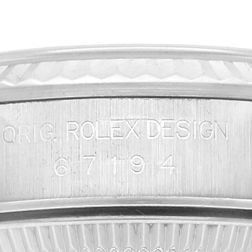 The image shows a close-up of the case side for a Rolex Oyster Perpetual 67194 Women's Stainless Steel Silver Dial 67194 Women's Stainless Steel Silver Dial, displaying "ORIG. ROLEX DESIGN" numbers.