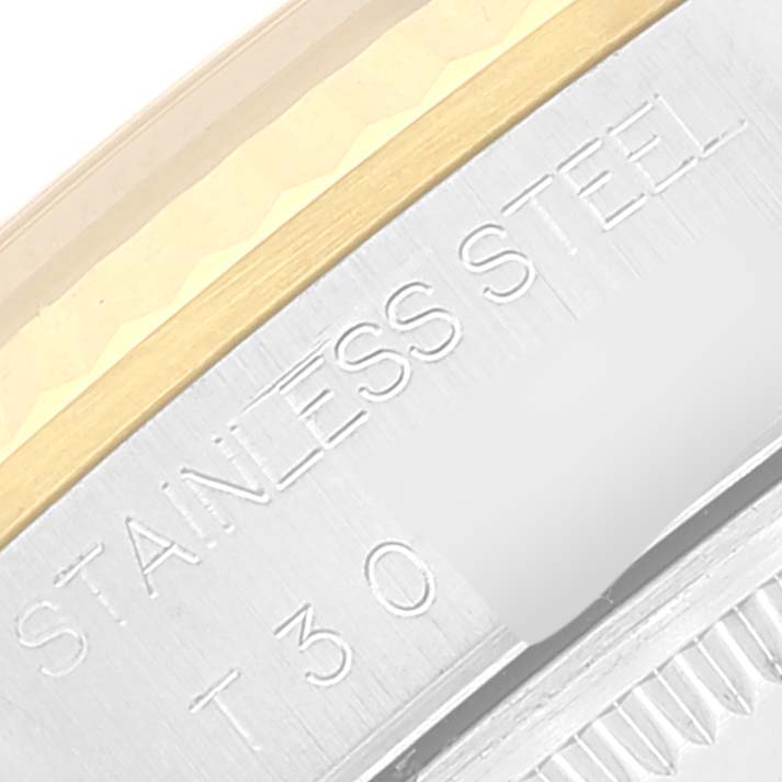 This close-up image of a Rolex Oyster Perpetual 14233 Men's Steel and Gold (two tone) Black Dial 14233 Men's Steel and Gold (two tone) Black Dial watch shows a partial view of the stainless steel case back and bezel.