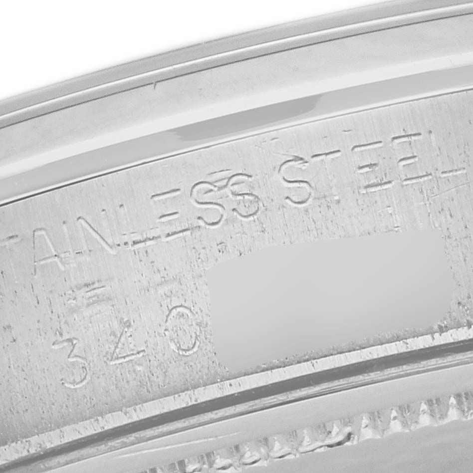 The image shows a close-up of the case back edge of the Vintage Collection model by Rolex, displaying the engraved "STAINLESS STEEL" text and partial serial number.