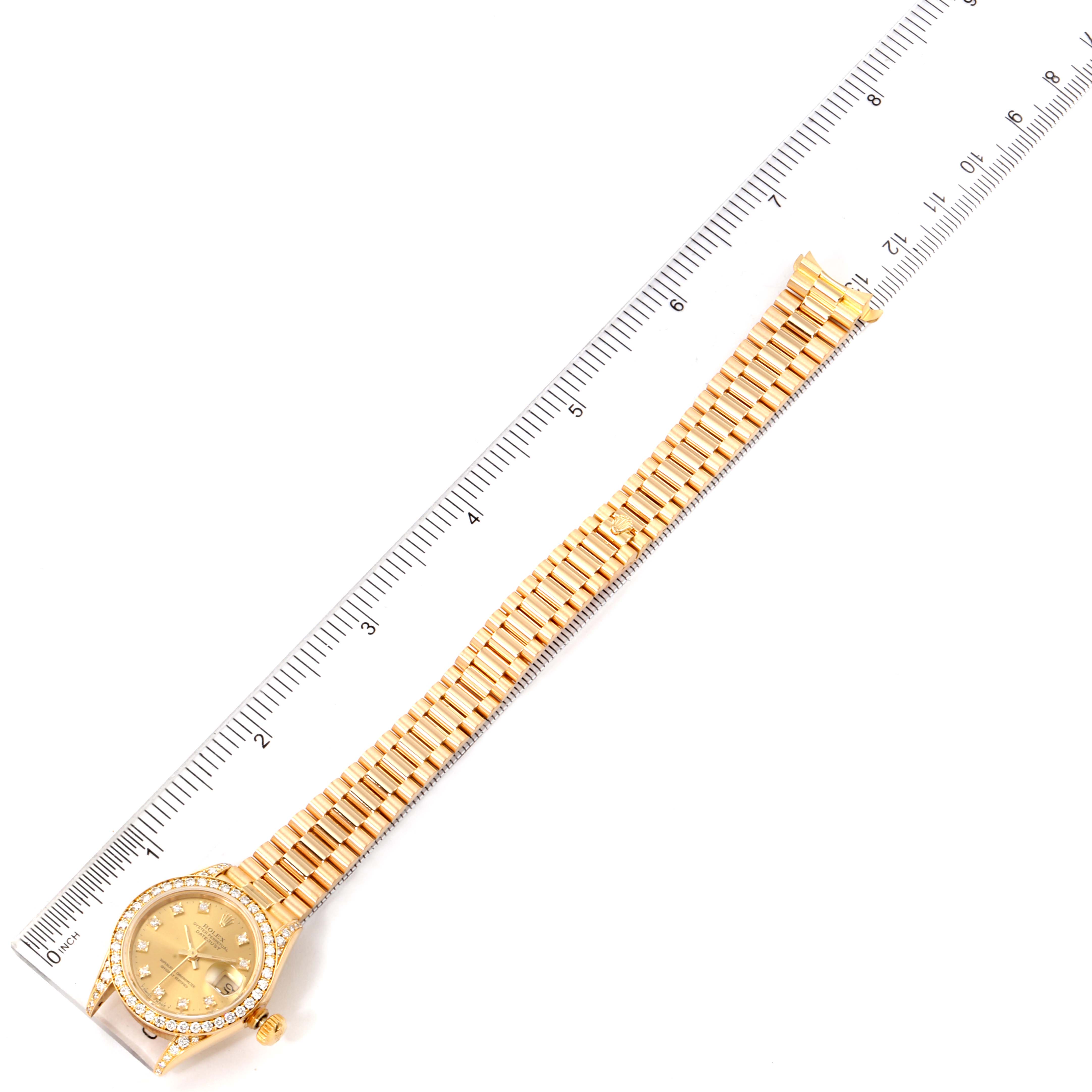 The image shows a top-down view of a Rolex President 69158 Women
s Yellow Gold Champagne Dial 69158 Women
s Yellow Gold Champagne Dial model watch, featuring the face, bezel, dial, bracelet, and a ruler measuring its length.