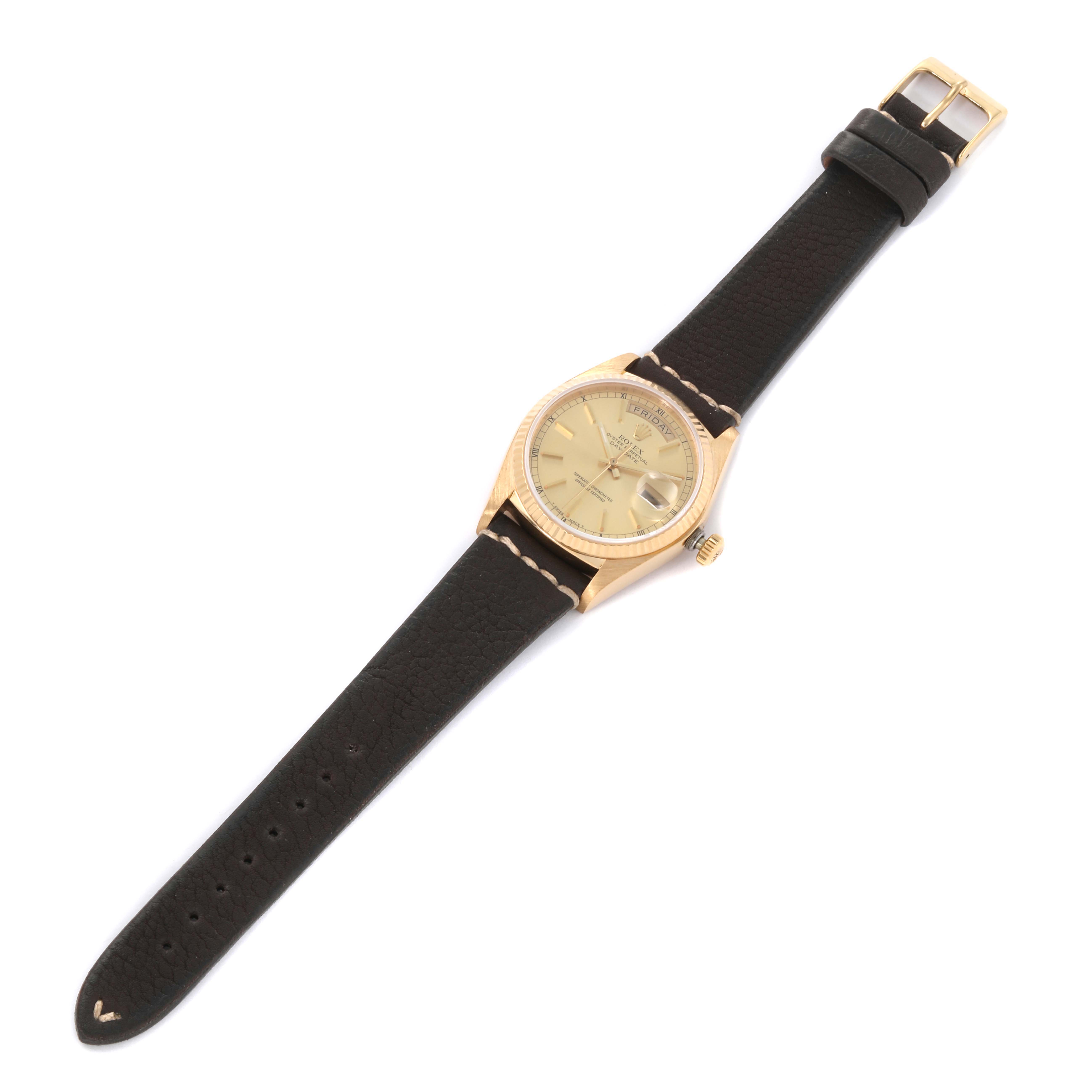 The Rolex President 18038 Men's Yellow Gold Champagne Dial 18038 Men's Yellow Gold Champagne Dial model watch is shown from a top-down angle, displaying its dial, bezel, crown, and leather strap.