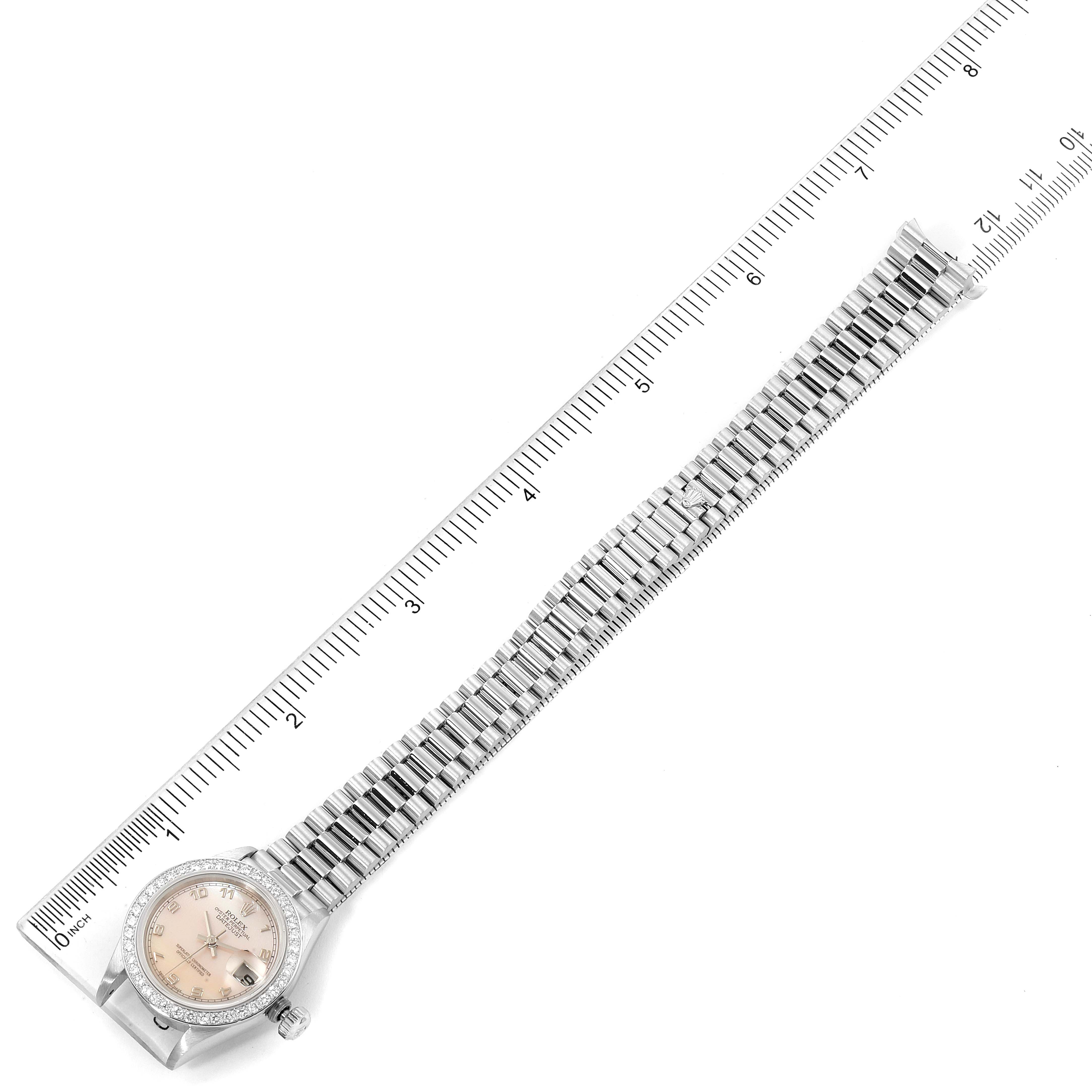 The watch shown is a Rolex President 69136 Women's Platinum Mother of Pearl Dial 69136 Women's Platinum Mother of Pearl Dial model, displayed flat with its face, bezel, and bracelet visible alongside a ruler.