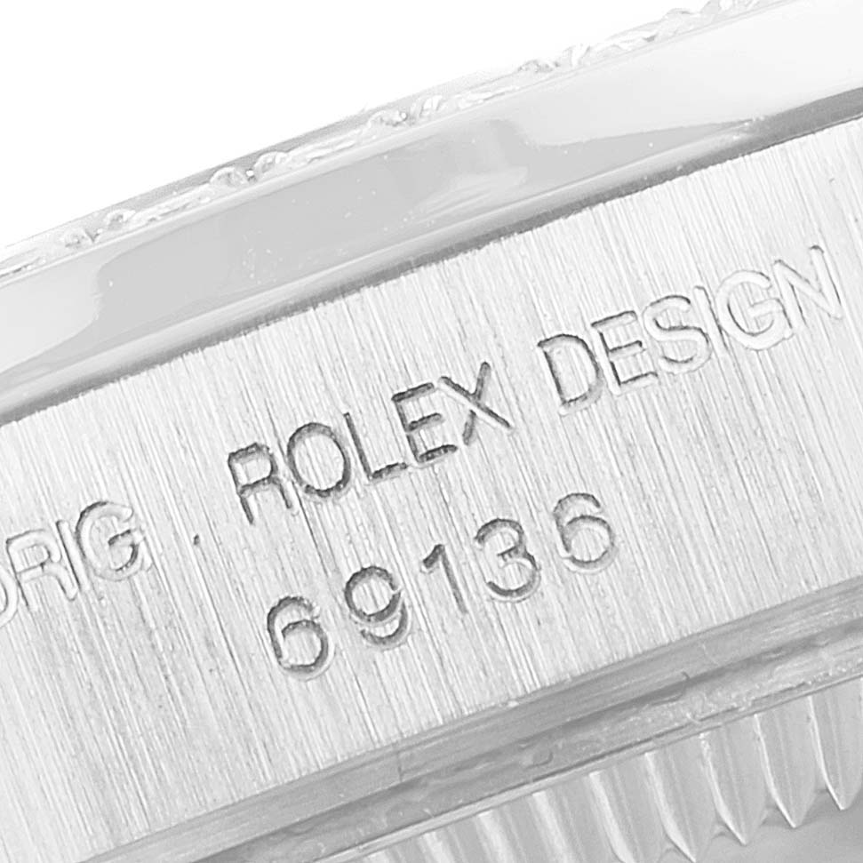 This image shows a close-up of the engraved bezel and part of the case of a Rolex President 69136 Women's Platinum Mother of Pearl Dial 69136 Women's Platinum Mother of Pearl Dial model watch.