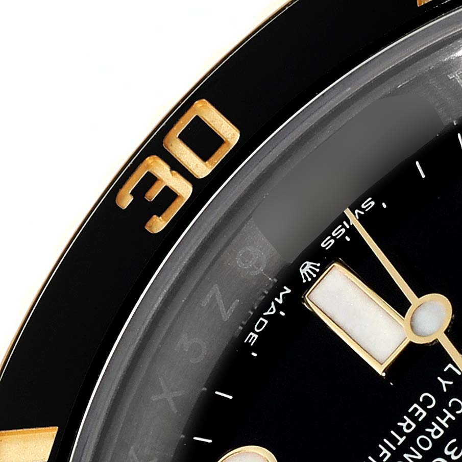 This close-up image shows the bezel and part of the dial of a Rolex Submariner 126613 Men
s Steel and Gold (two tone) Black Dial 126613 Men
s Steel and Gold (two tone) Black Dial, highlighting its "30" marking and "Swiss Made" label.