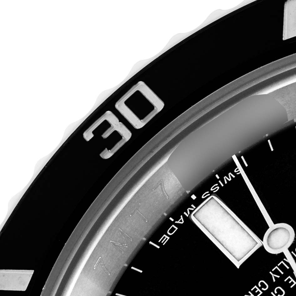 The image shows a close-up of the Rolex Submariner 114060 Men
s Stainless Steel Black Dial 114060 Men
s Stainless Steel Black Dial
s bezel, dial, and partial view of the hands.