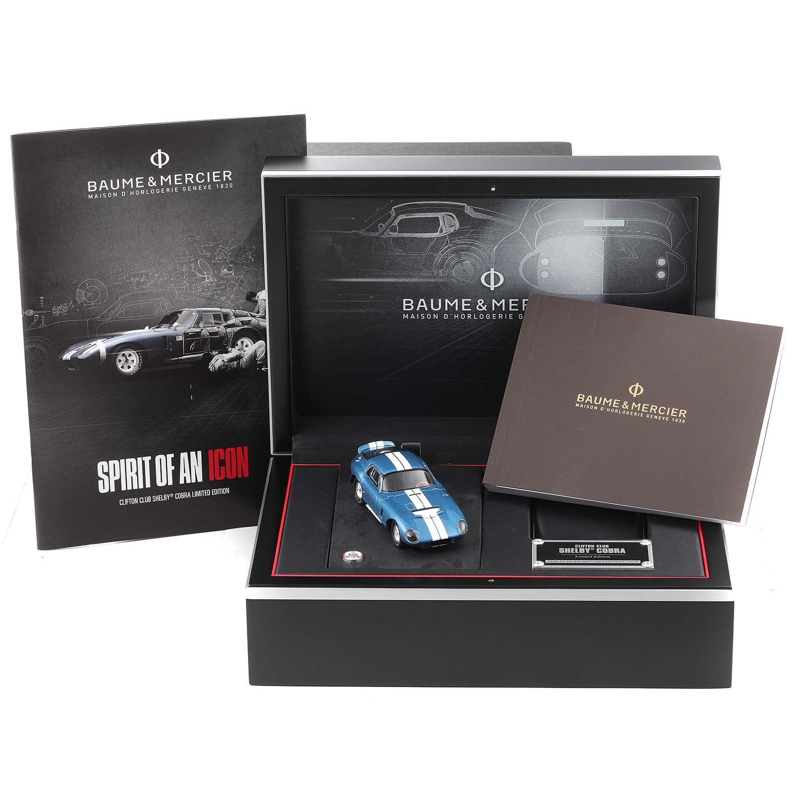 The image shows the Baume & Mercier Clifton M0A10342 Men's Stainless Steel Silver Dial M0A10342 Men's Stainless Steel Silver Dial model packaging with a miniature blue car and accompanying materials.