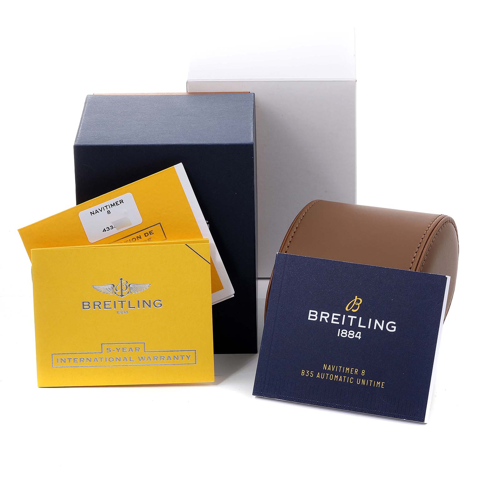 The image shows the packaging, warranty cards, and a leather case for the Breitling Navitimer watch.