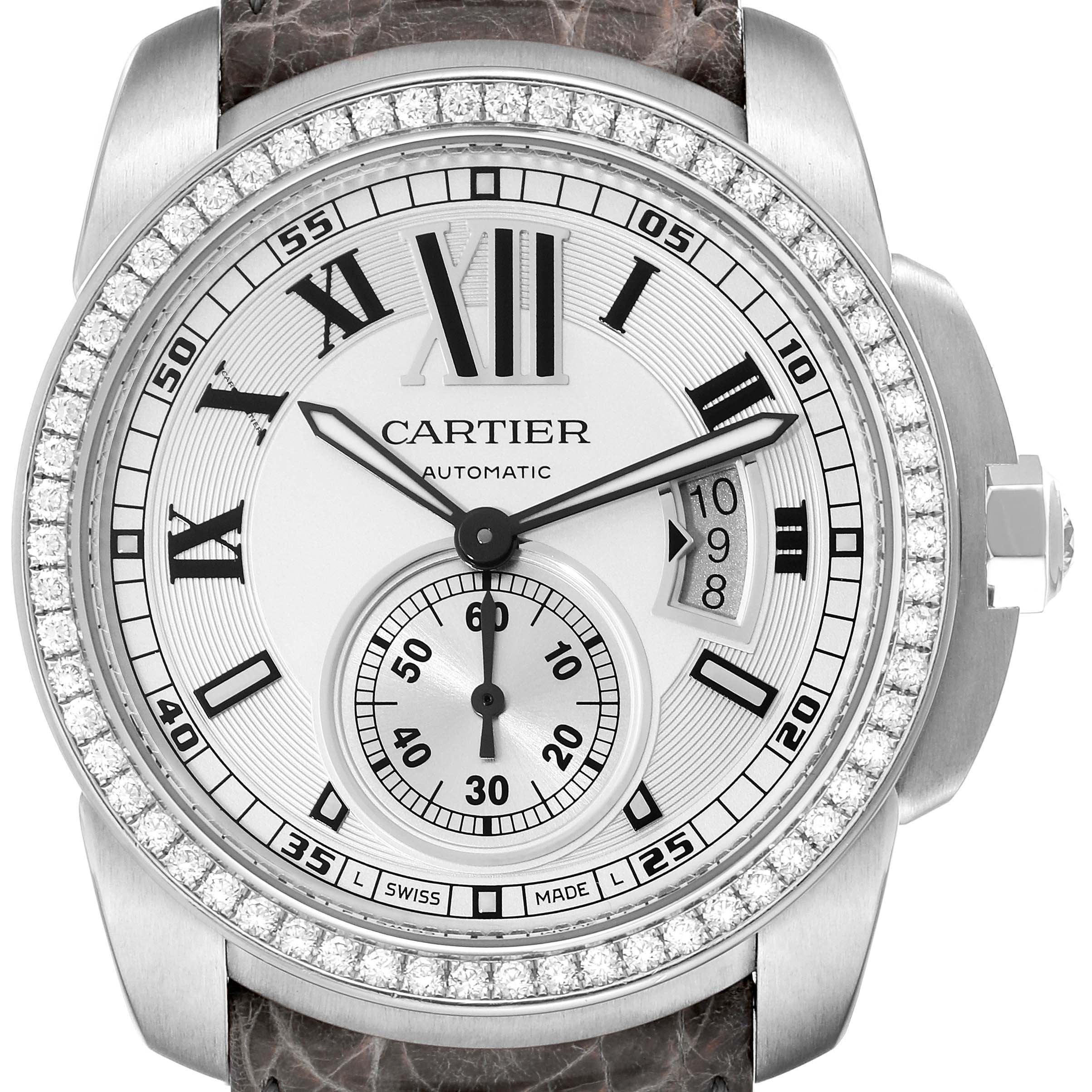 This image shows a frontal view of the Calibre de Cartier watch by Cartier, featuring a silver dial, Roman numerals, and diamond bezel.