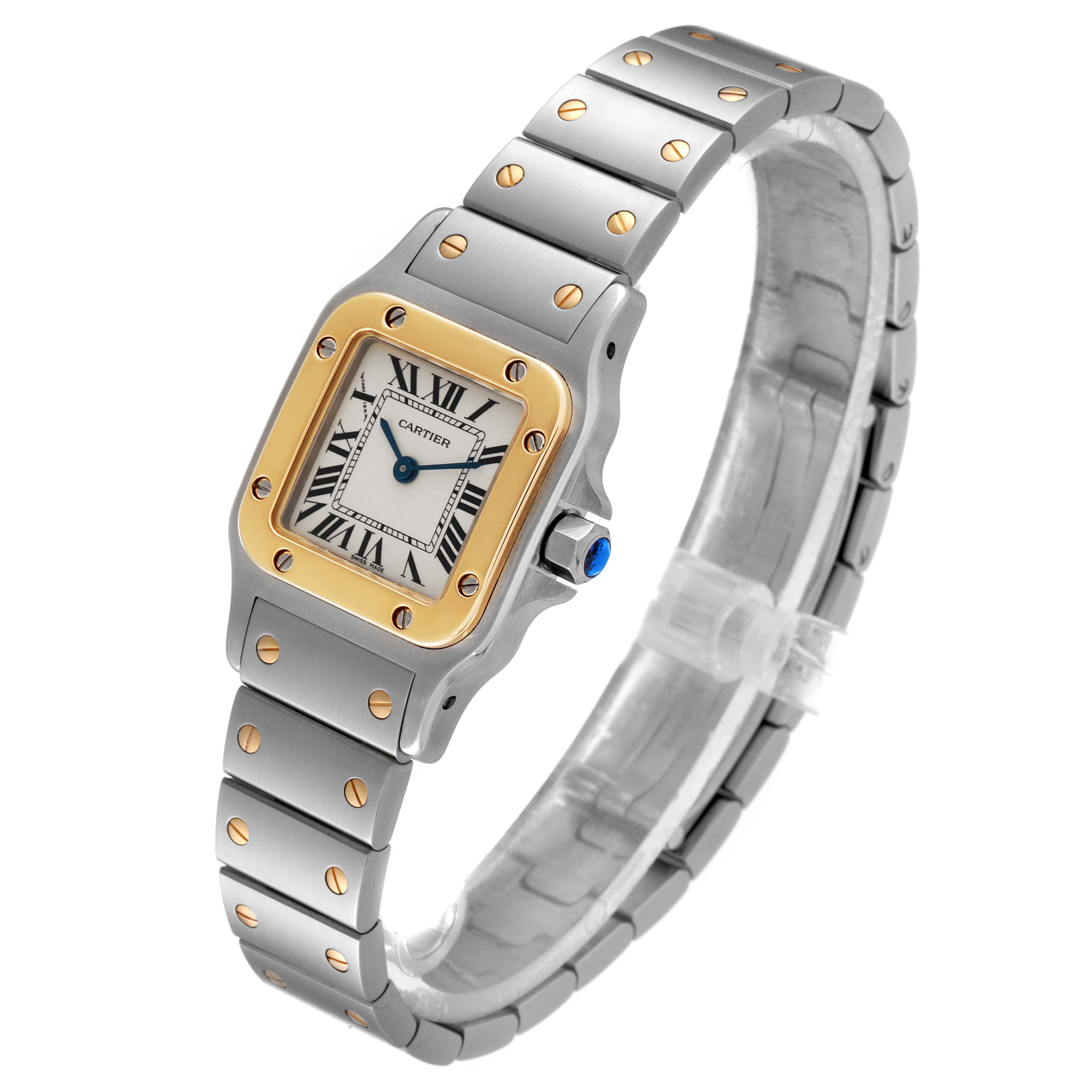 The image shows a Santos model watch by Cartier from a three-quarter angle, highlighting its bezel, dial, and bracelet.