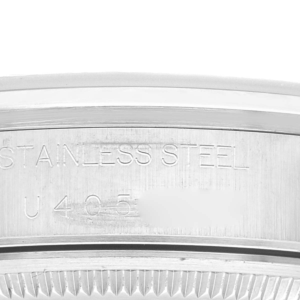 The image shows a close-up of the side of a Rolex Air-King 14000 Men's Stainless Steel Pink Dial 14000 Men's Stainless Steel Pink Dial watch, featuring the engraved text "STAINLESS STEEL" and part of the serial number.