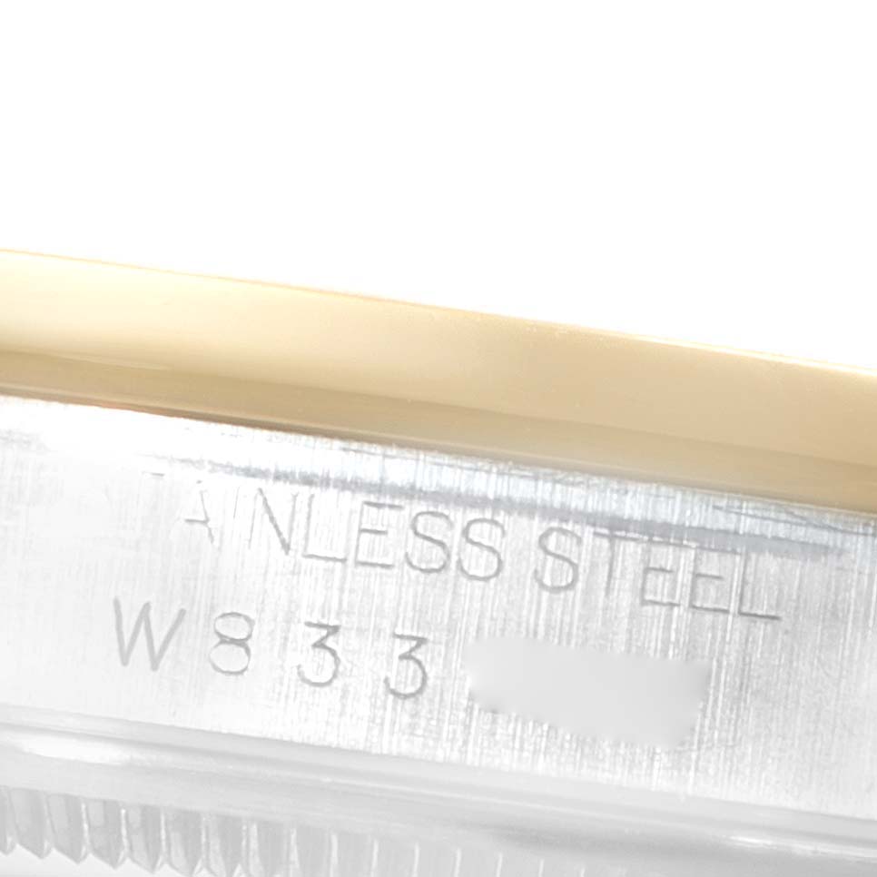 The image shows a close-up of the side engraving on a Rolex Datejust 16203 Men
s Steel and Gold (two tone) Grey Dial 16203 Men
s Steel and Gold (two tone) Grey Dial watch, highlighting "STAINLESS STEEL" and part of the serial number.