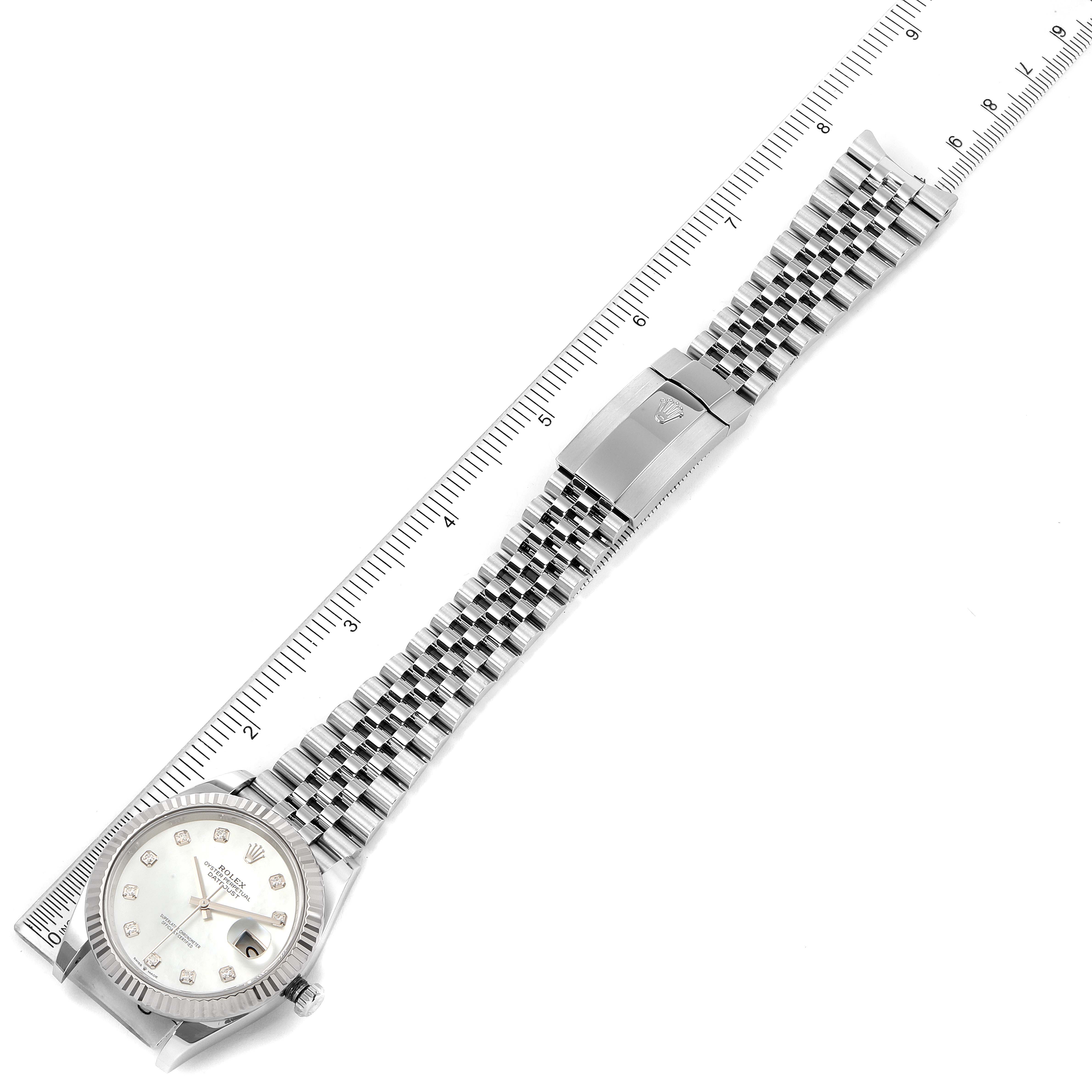 The image shows a top-down view of the Rolex Datejust 41 126334 Men's Stainless Steel Mother of Pearl Dial 126334 Men's Stainless Steel Mother of Pearl Dial watch, displaying the face, crown, bracelet, and clasp, next to a ruler.