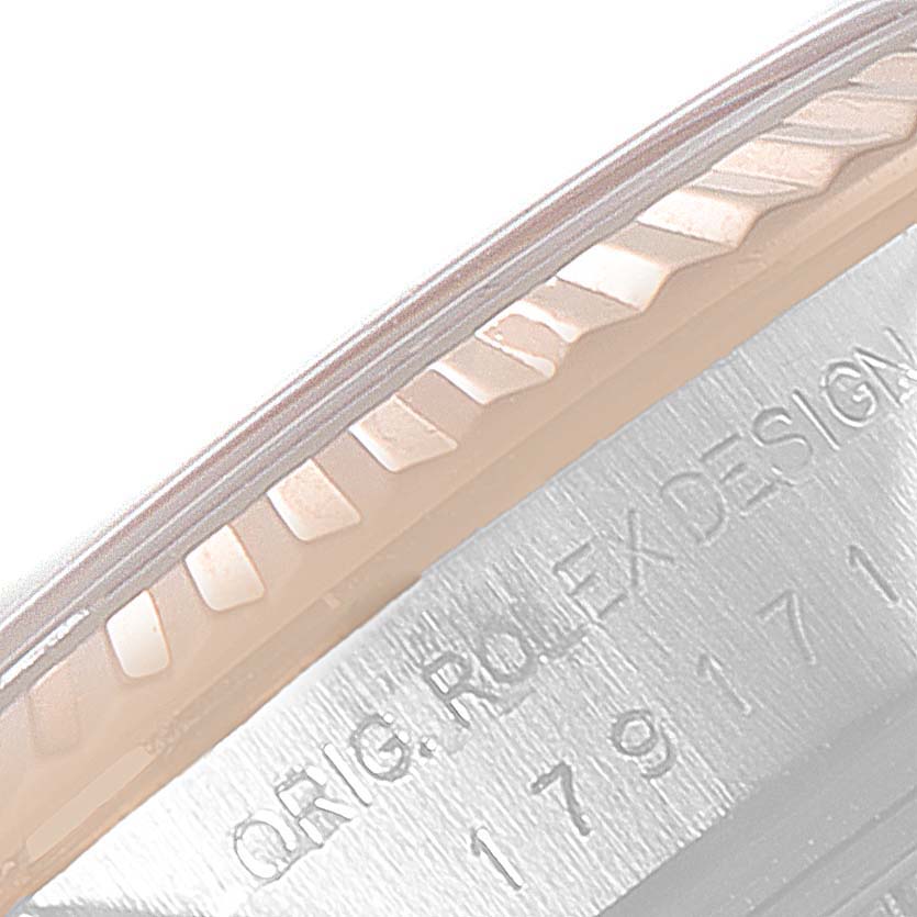 This image shows a close-up of the fluted bezel and part of the casing of a Rolex Datejust 179171 Women's Steel and Gold (two tone) Pink Dial 179171 Women's Steel and Gold (two tone) Pink Dial watch.