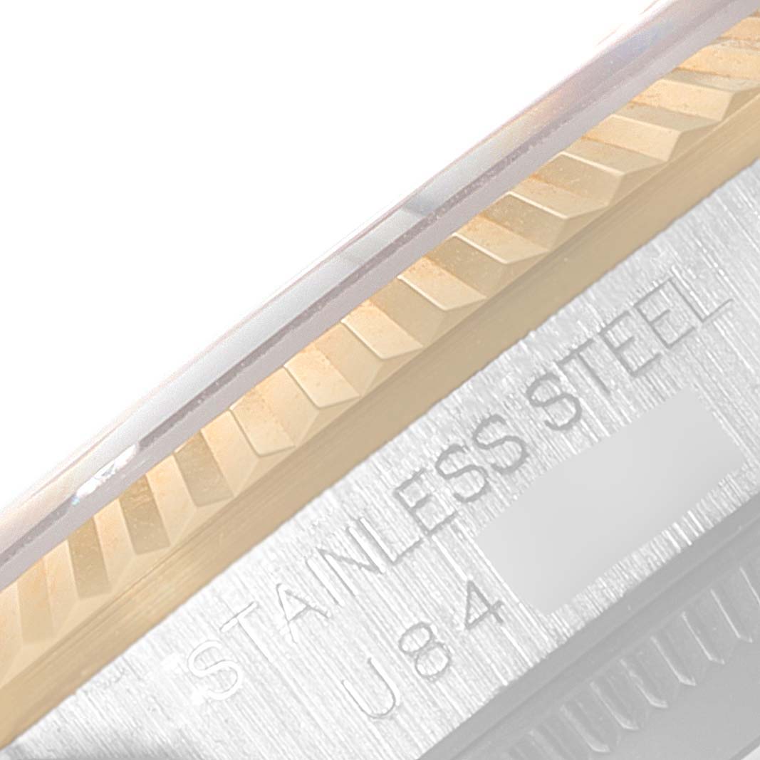 The image shows a close-up of the Rolex Mid-Size 68273 Women
s Steel and Gold (two tone) Champagne Dial 68273 Women
s Steel and Gold (two tone) Champagne Dial model
s fluted bezel and part of the engraved stainless steel case.