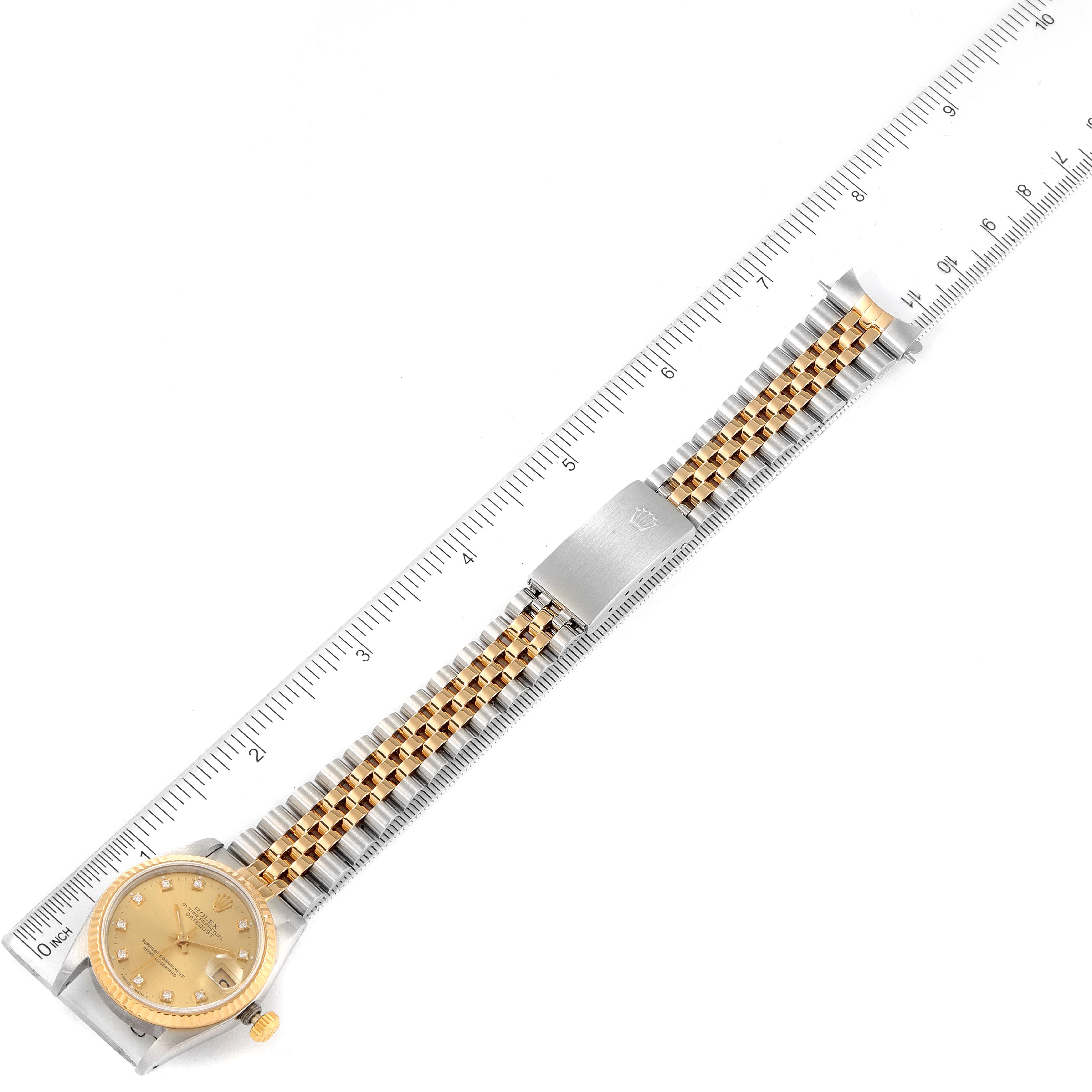 The image shows a full-length view of a Rolex Mid-Size 68273 Women
s Steel and Gold (two tone) Champagne Dial 68273 Women
s Steel and Gold (two tone) Champagne Dial watch, including the face, bracelet, and clasp, alongside a ruler for size reference.