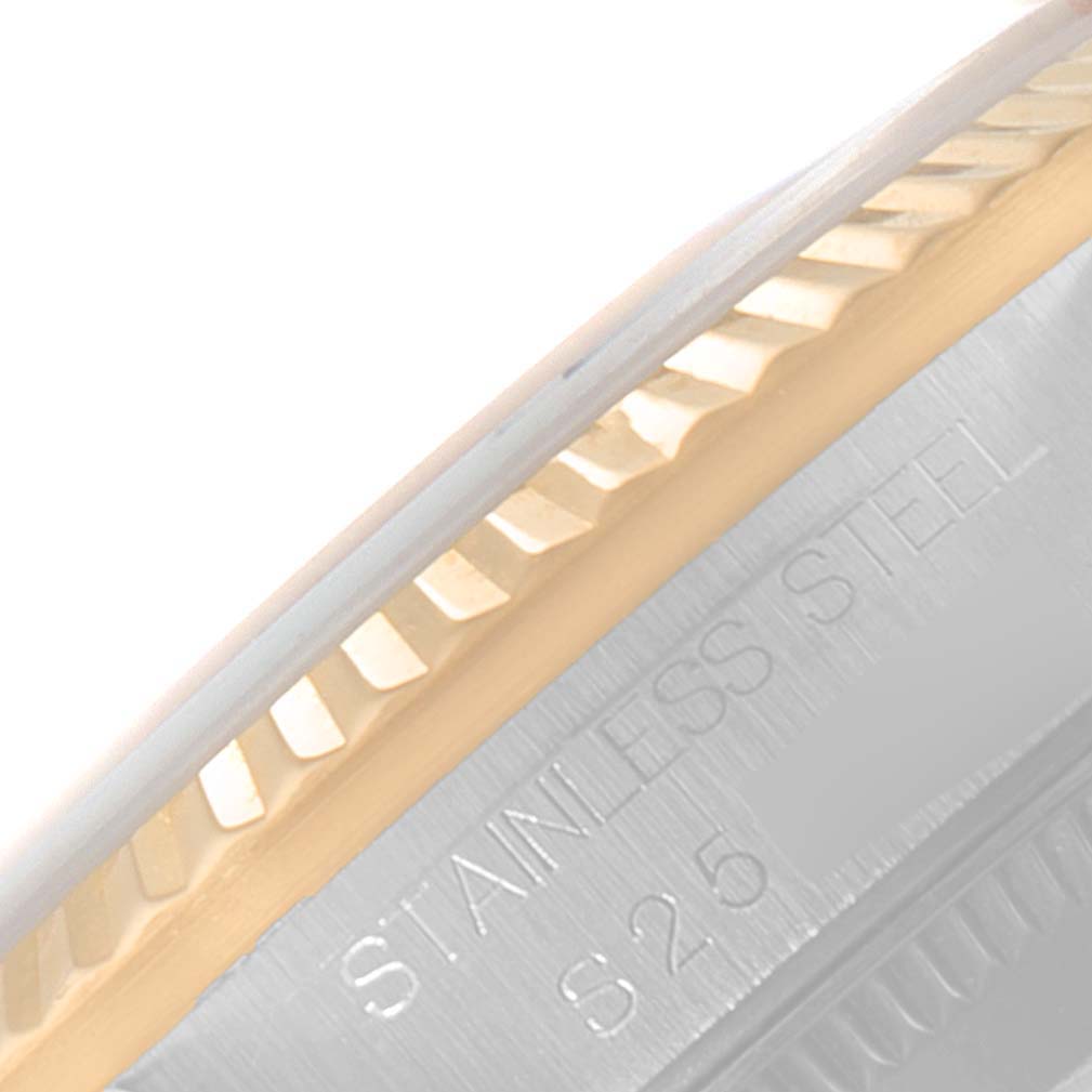 The image shows a close-up of the bezel and part of the case of a Mid-Size Rolex watch, with "STAINLESS STEEL" engraved.