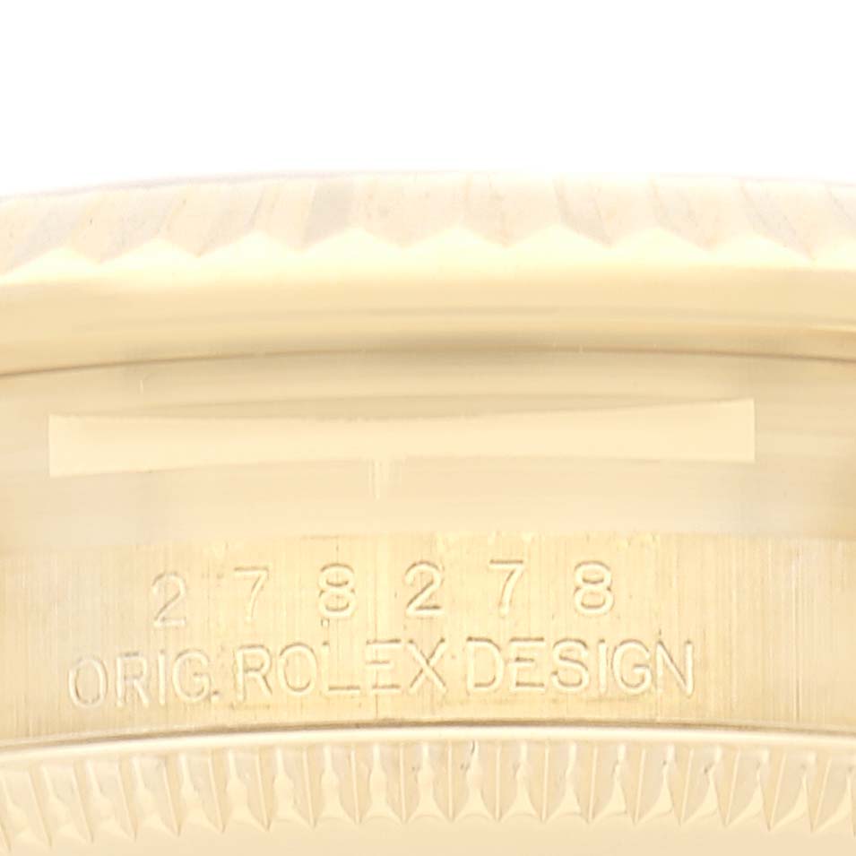 This image shows the side of the bezel and the engraved serial number of a Rolex Mid-Size model watch.