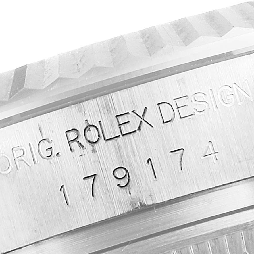 This is a close-up of the engraved case serial number on the side of a Rolex Datejust 179174 Women's Stainless Steel Mother of Pearl Dial 179174 Women's Stainless Steel Mother of Pearl Dial watch, highlighting its distinct fluted bezel.