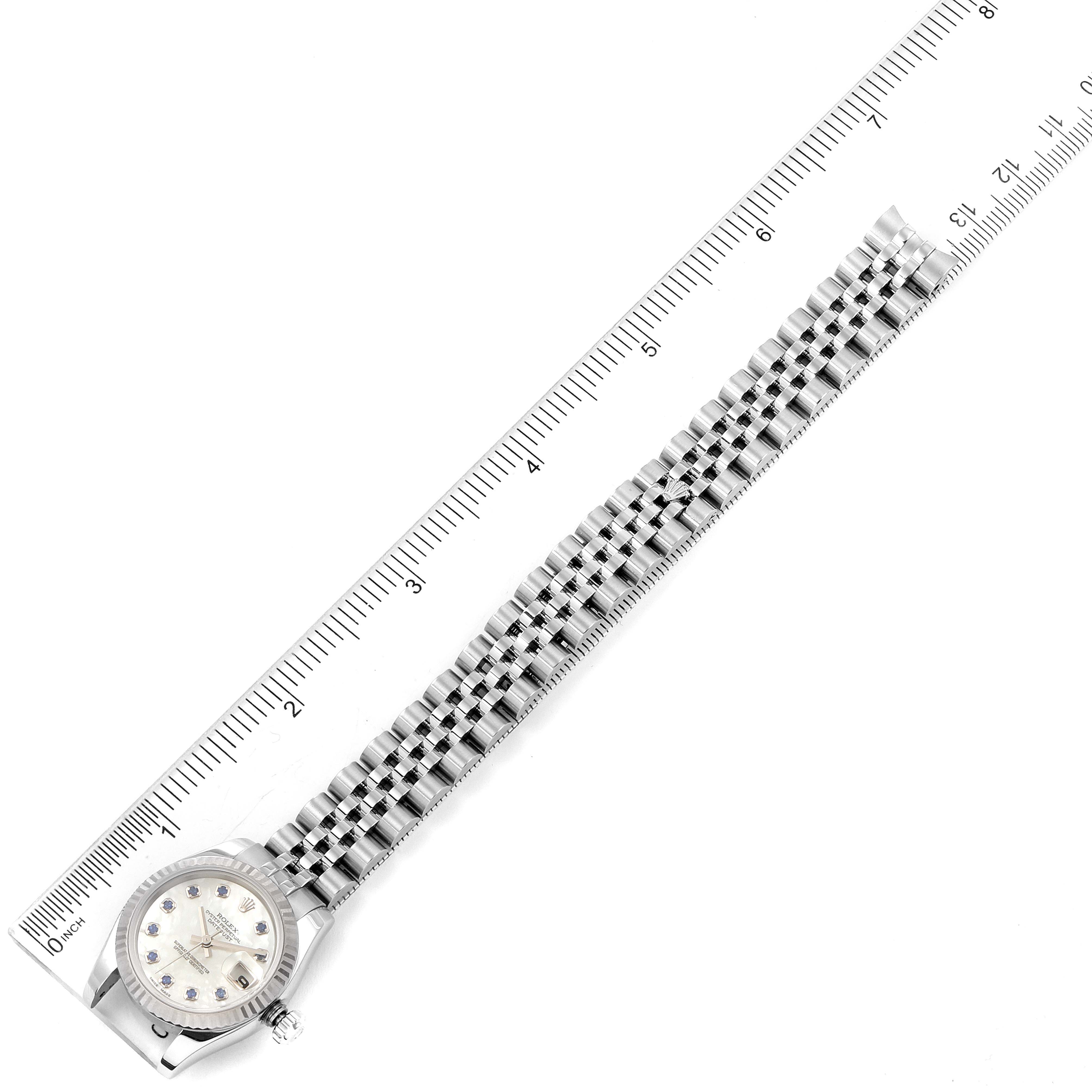 The image shows a Rolex Datejust 179174 Women's Stainless Steel Mother of Pearl Dial 179174 Women's Stainless Steel Mother of Pearl Dial watch laid flat next to a ruler, displaying the entire face and band.
