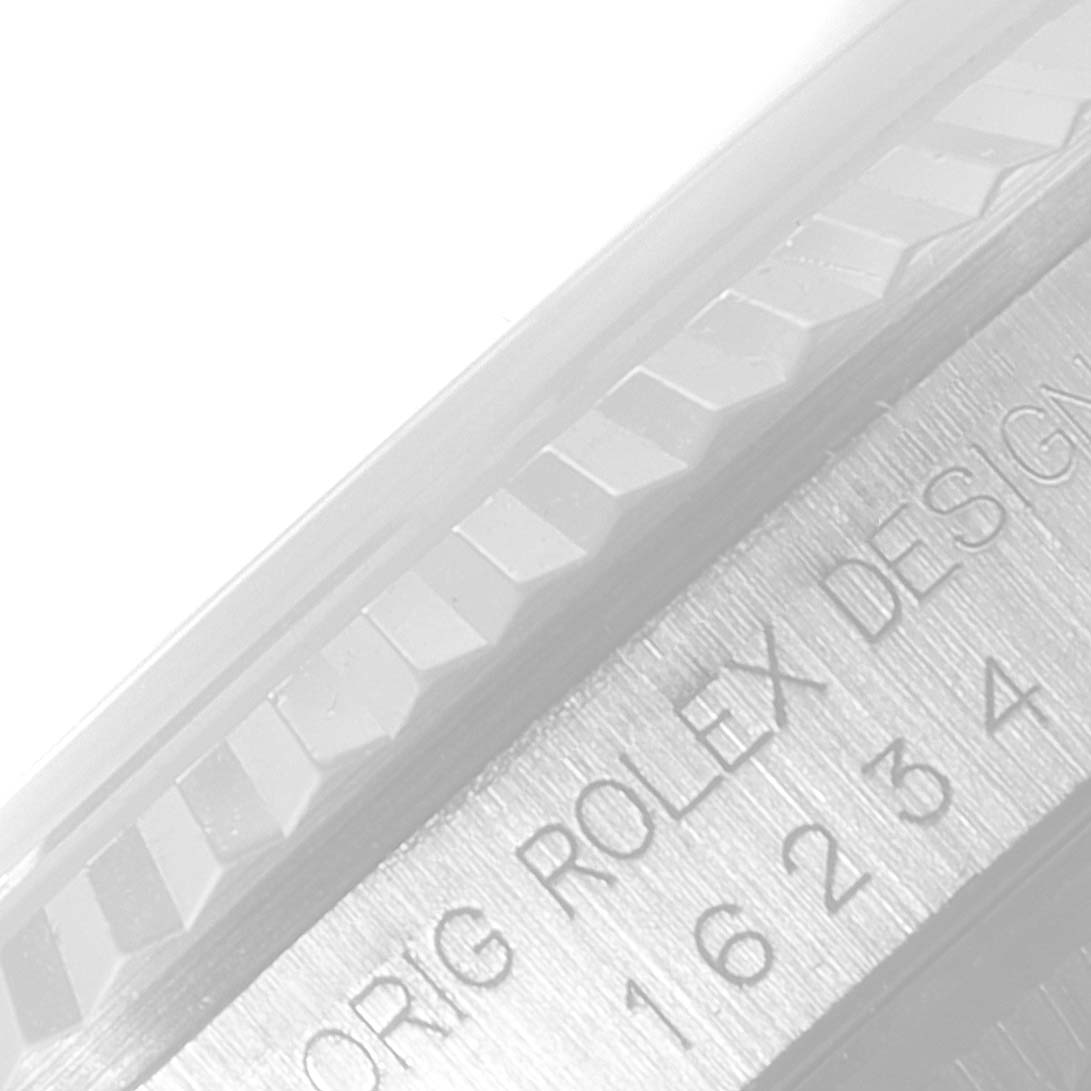 This image shows a close-up of the side of a Rolex Datejust 16234 Men's Stainless Steel Grey Dial 16234 Men's Stainless Steel Grey Dial watch, highlighting the fluted bezel and engraved case.