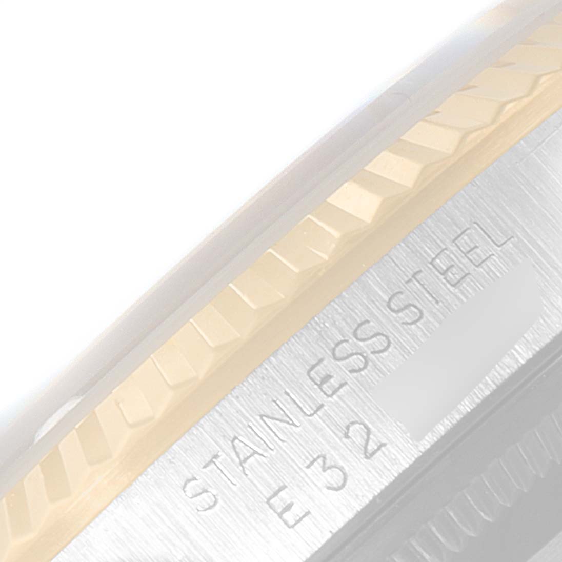 This image shows a close-up of the fluted bezel and part of the case with "STAINLESS STEEL" engraving on a Rolex Datejust 16233 Men's Steel and Gold (two tone) Champagne Dial 16233 Men's Steel and Gold (two tone) Champagne Dial watch.