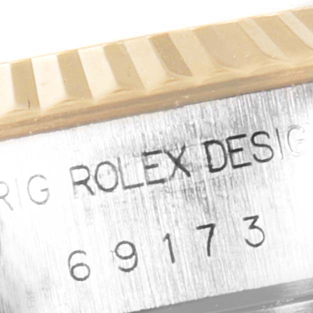 Close-up of the Rolex Datejust 69173 Women's Steel and Gold (two tone) White Dial 69173 Women's Steel and Gold (two tone) White Dial engraving on the side with a partial view of the fluted bezel.