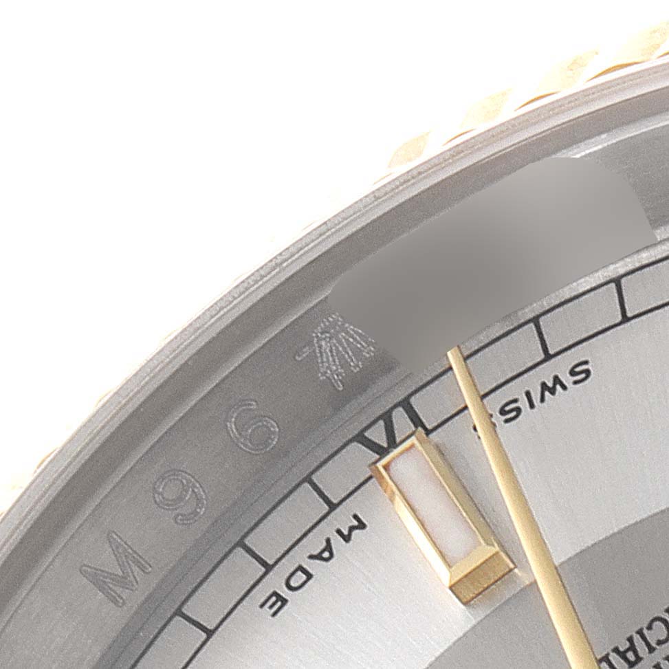 This close-up of a Rolex Datejust 116233 Men's Steel and Gold (two tone) Silver Dial 116233 Men's Steel and Gold (two tone) Silver Dial watch shows the bezel, part of the dial, and markers at an angled view.