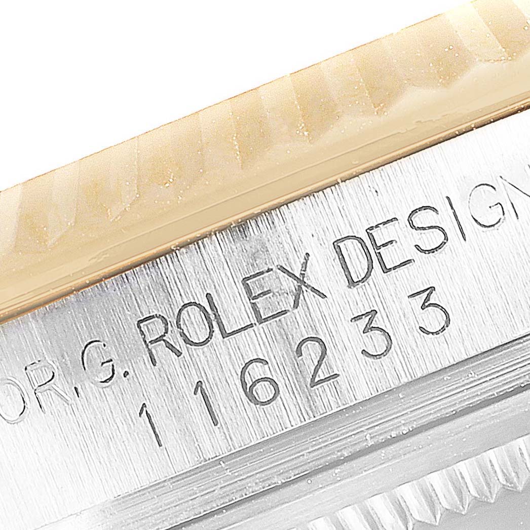 This image shows a close-up view of the engraved case back of the Rolex Datejust 116233 Men's Steel and Gold (two tone) Silver Dial 116233 Men's Steel and Gold (two tone) Silver Dial model, revealing part of the bezel and the model number.