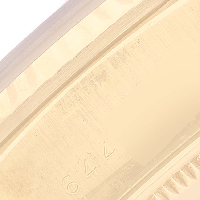 This close-up image of the Rolex President 18038 Men's Yellow Gold Champagne Dial 18038 Men's Yellow Gold Champagne Dial model shows a partial view of the watch case edge with part of the serial number engraved.