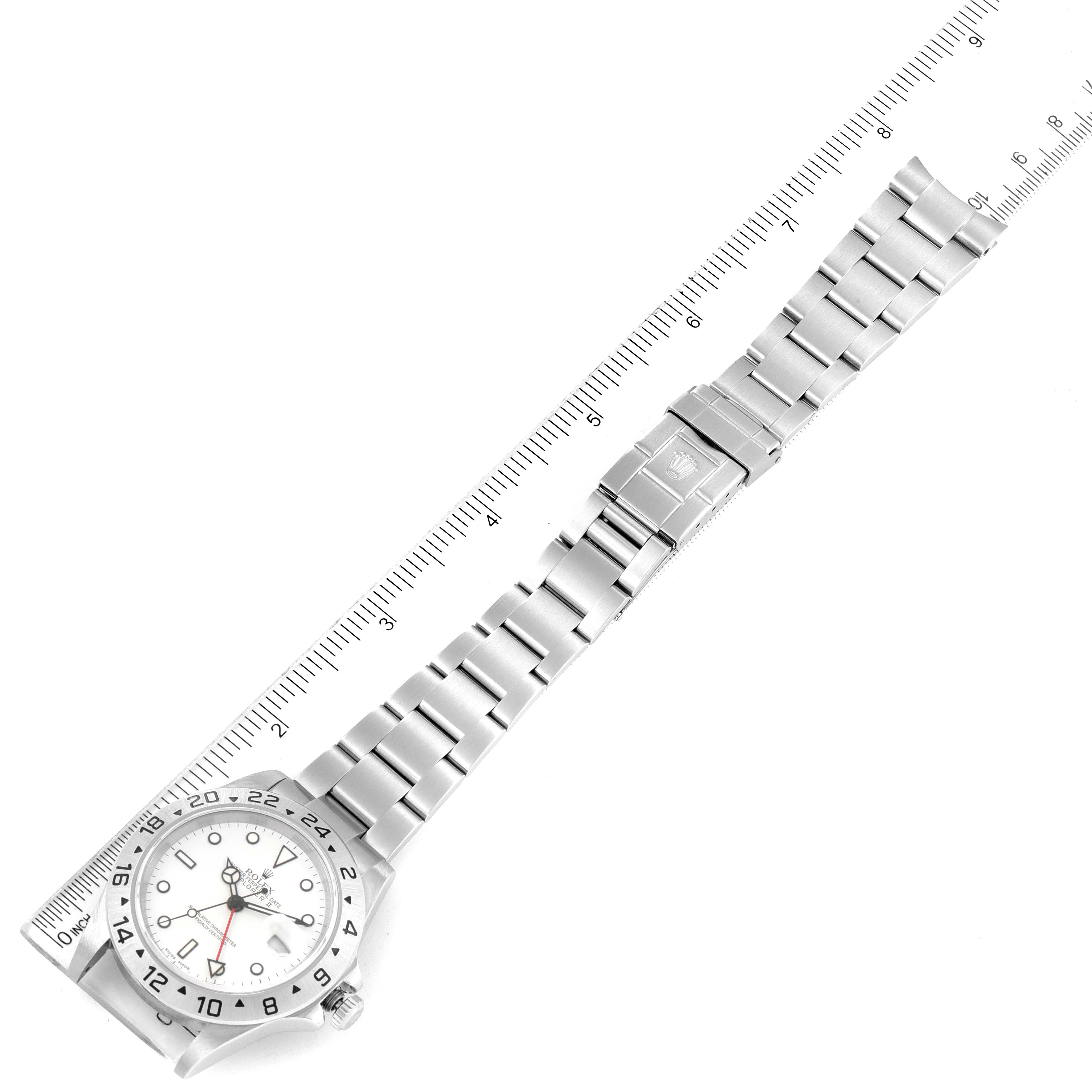 This image shows a top-down view of a Rolex Explorer 16570 Men's Stainless Steel White Dial 16570 Men's Stainless Steel White Dial watch with a stainless steel bracelet alongside a ruler for scale.