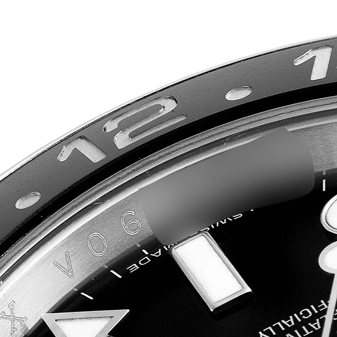 This close-up image of a Rolex GMT-Master 116710 Men
s Stainless Steel Black Dial 116710 Men
s Stainless Steel Black Dial watch shows the bezel with the number 12 and parts of the dial.