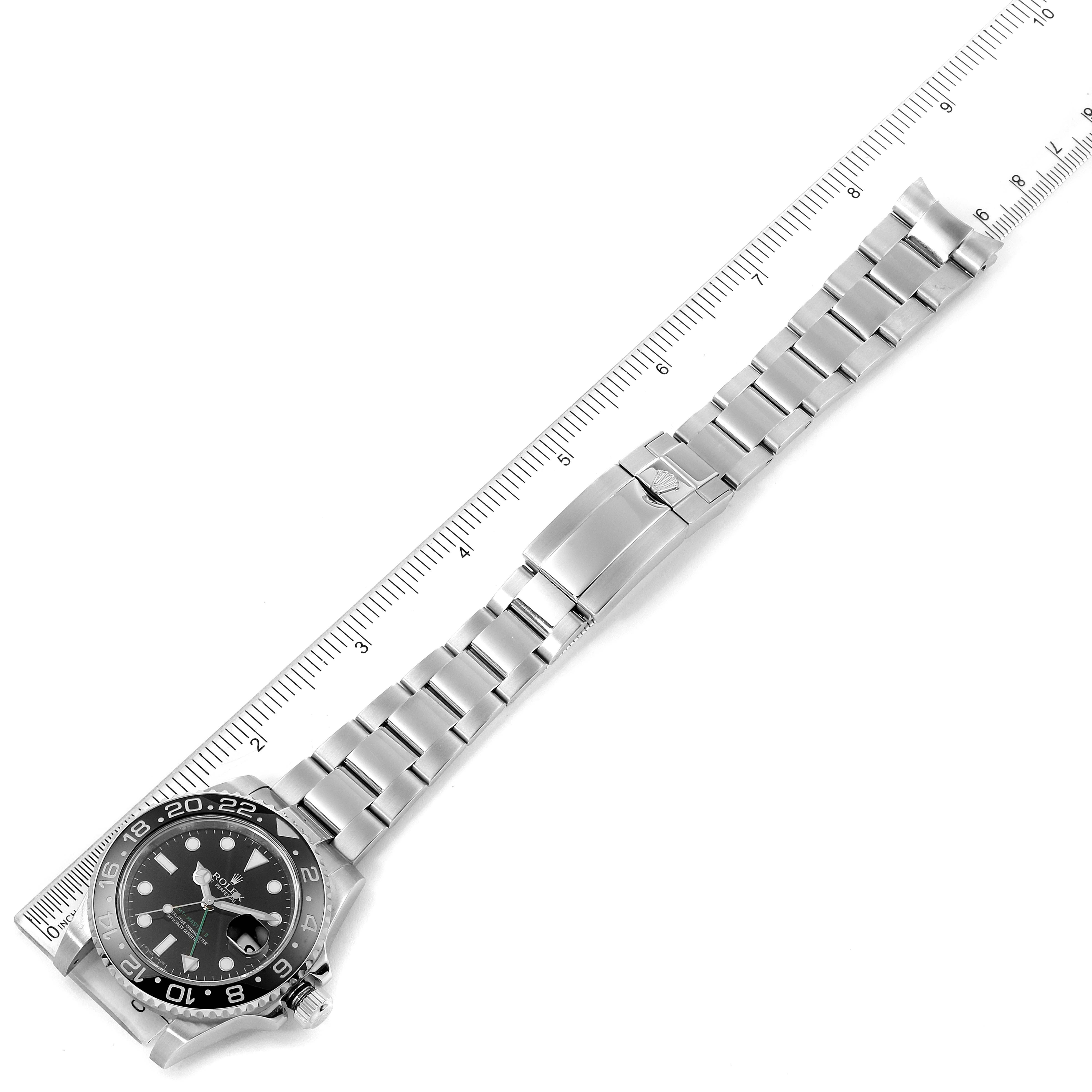 A top-down view of a Rolex GMT-Master 116710 Men
s Stainless Steel Black Dial 116710 Men
s Stainless Steel Black Dial watch showcasing the watch face and metal bracelet with a ruler along its length.