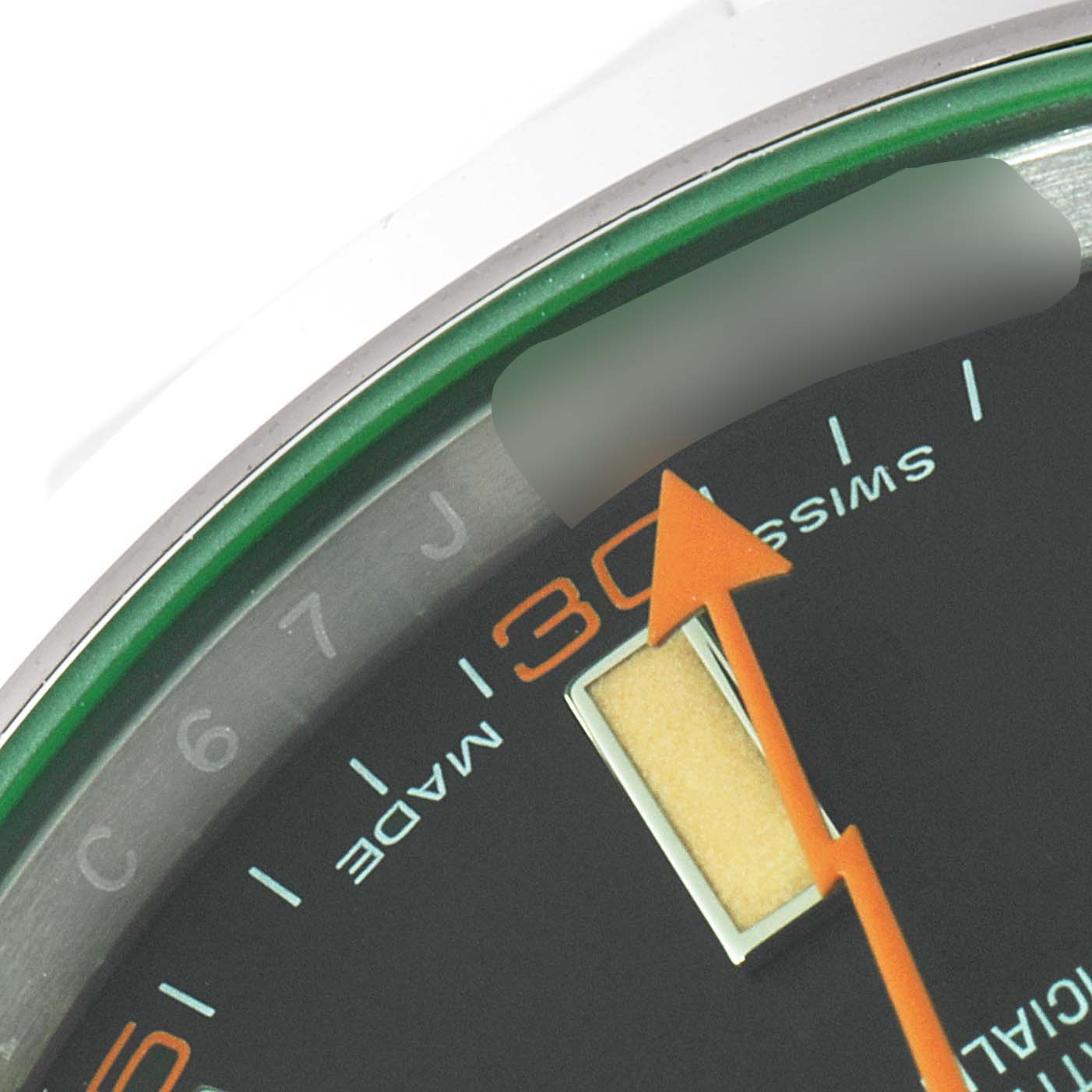 The image shows a close-up of the Milgauss model by Rolex, focusing on the dial, minute markers, and part of the hand.