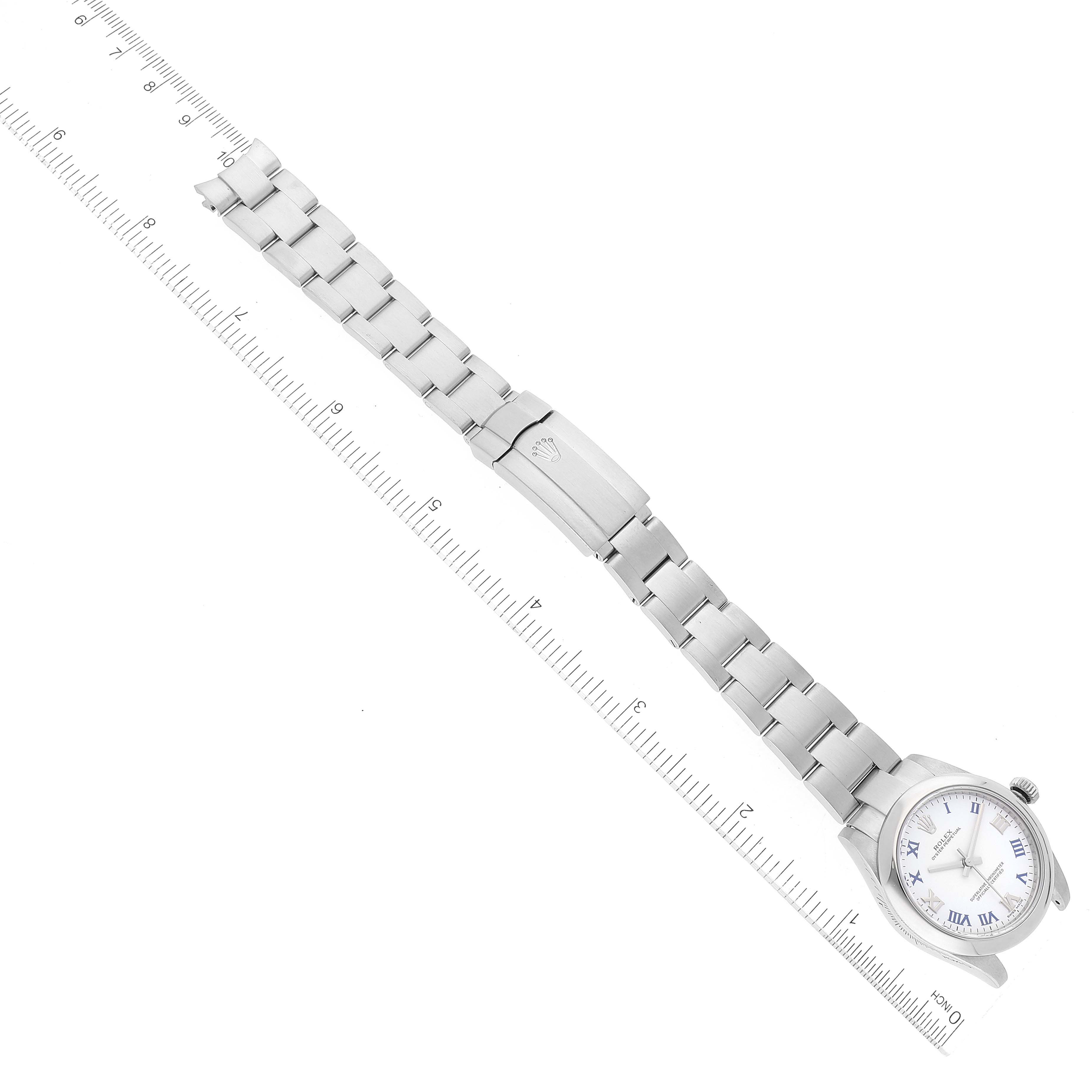 The Rolex Mid-Size 177200 Women's Stainless Steel White Dial 177200 Women's Stainless Steel White Dial model watch is shown laid flat with its metal band fully extended alongside a ruler.