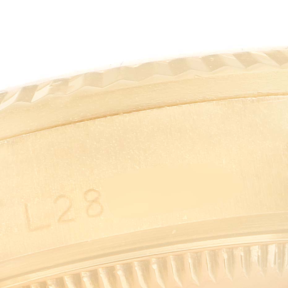 This image shows a close-up of the side of a Rolex President 68278 Women
s Yellow Gold Champagne Dial 68278 Women
s Yellow Gold Champagne Dial model watch, focusing on the serial number area and the edge of the bezel.