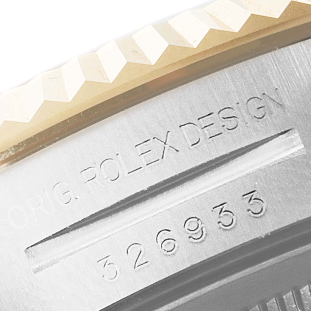This close-up shows the engraved case side and part of the bezel of a Rolex Sky-Dweller 326933 Men's Steel and Gold (two tone) White Dial 326933 Men's Steel and Gold (two tone) White Dial watch.