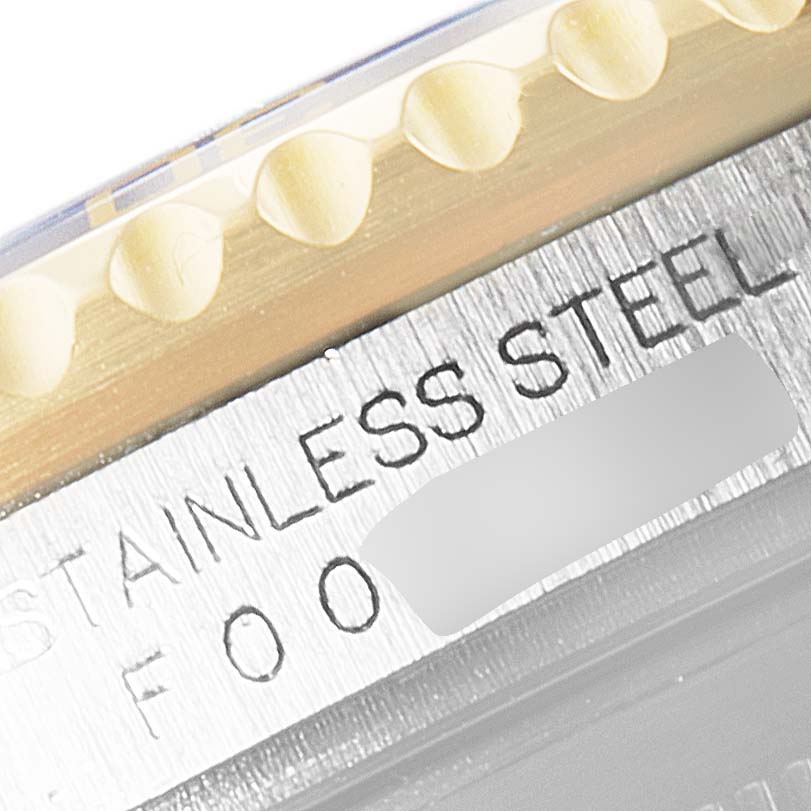 This close-up shows the bezel and case of a Rolex Submariner 16613 Men
s Steel and Gold (two tone) Blue Dial 16613 Men
s Steel and Gold (two tone) Blue Dial watch with engraved text indicating "STAINLESS STEEL."