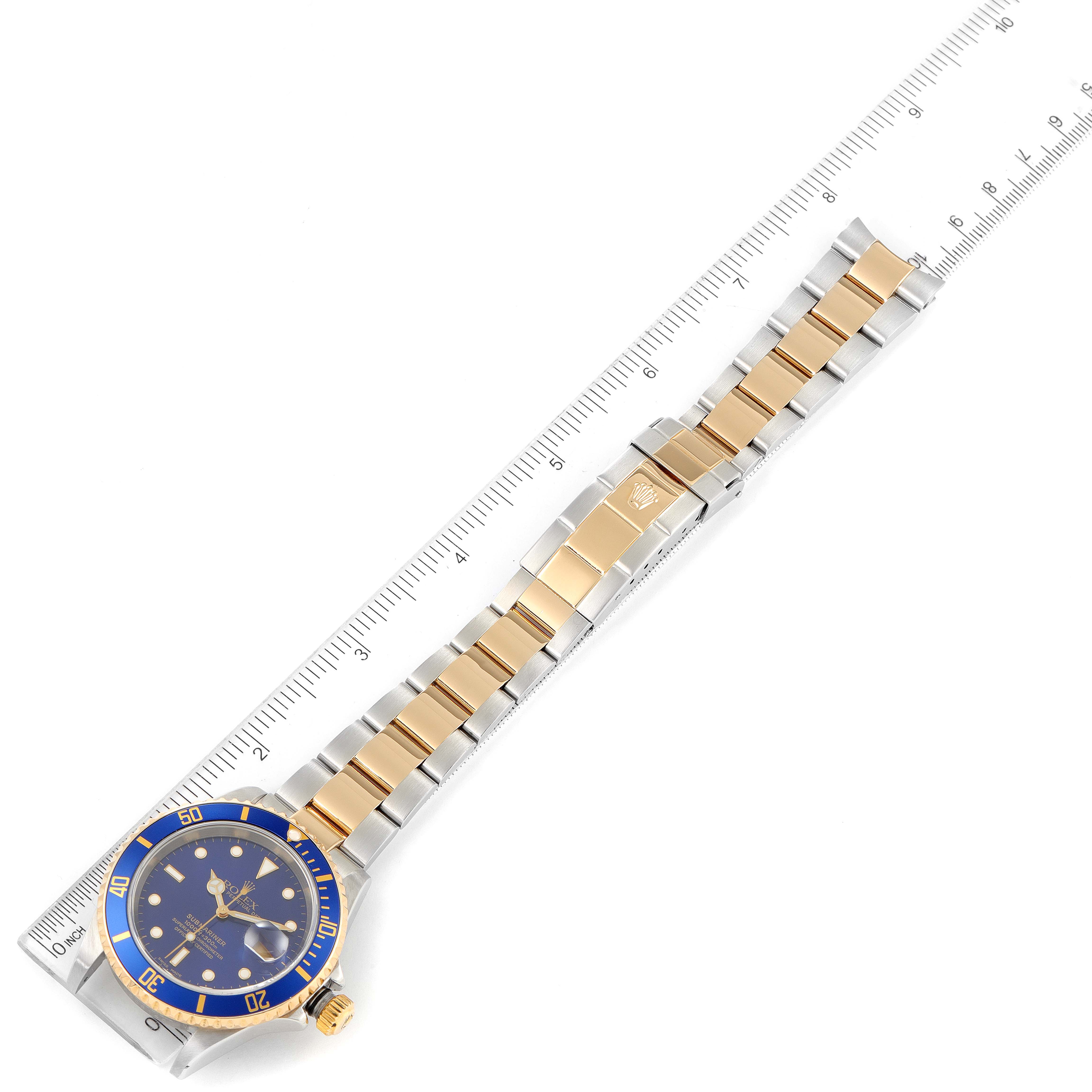 This image shows a Rolex Submariner 16613 Men
s Steel and Gold (two tone) Blue Dial 16613 Men
s Steel and Gold (two tone) Blue Dial watch from a top-down angle, highlighting its blue dial, gold and silver bracelet, and clasp.
