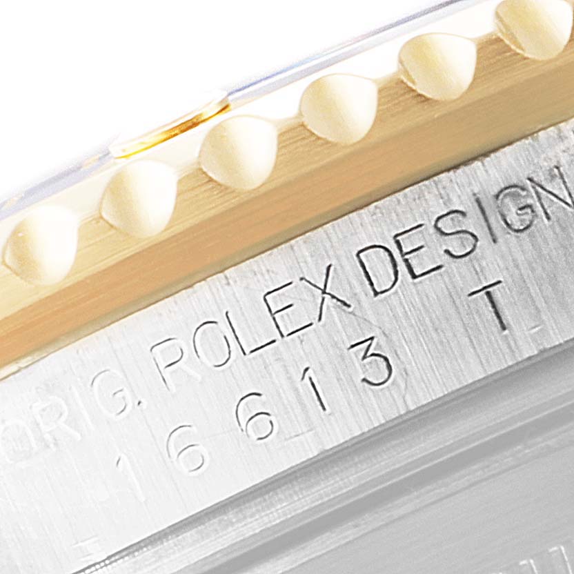 This image shows a close-up of the engraved side of a Rolex Submariner 16613 Men
s Steel and Gold (two tone) Blue Dial 16613 Men
s Steel and Gold (two tone) Blue Dial watch, displaying its model number and design details.
