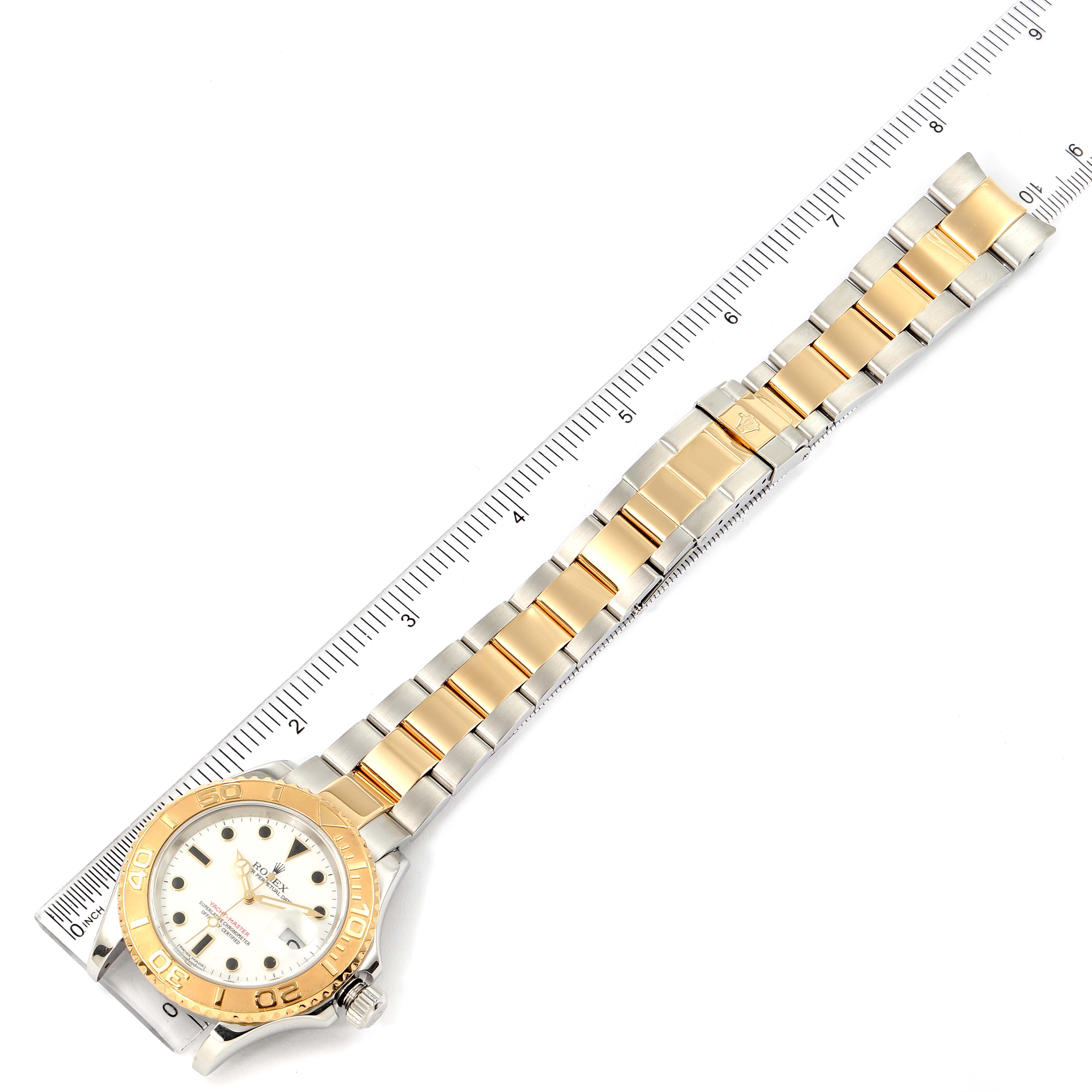 The Rolex Yacht-Master 16623 Men's Steel and Gold (two tone) White Dial 16623 Men's Steel and Gold (two tone) White Dial watch is shown laid flat with its face, bezel, and bracelet visible, positioned along a ruler.
