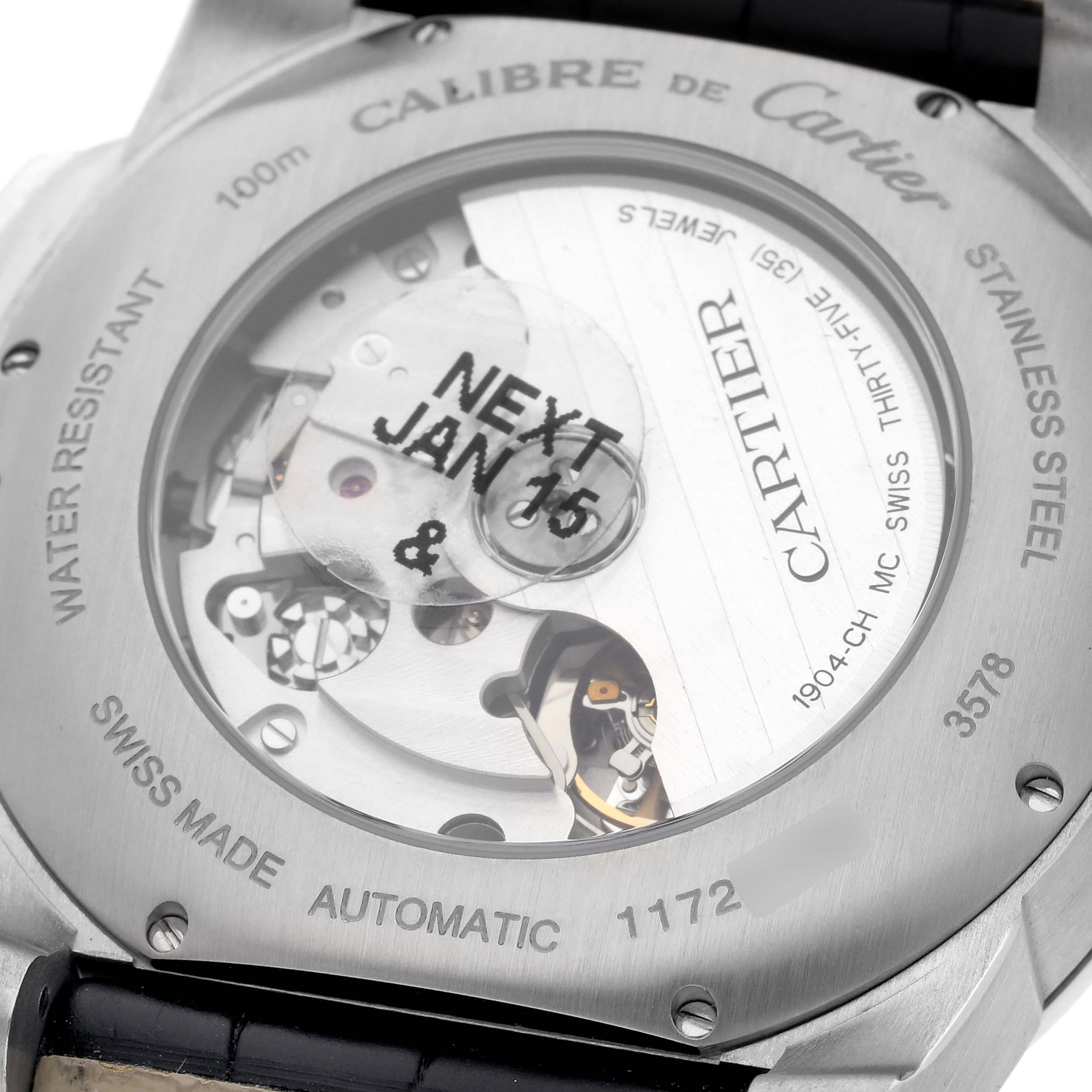 The image shows the back of a Calibre de Cartier watch, highlighting its automatic movement and transparent case back.